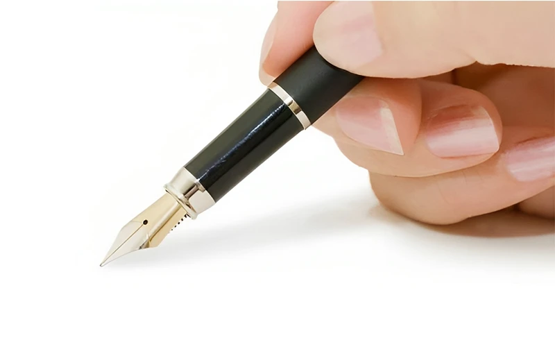 עט נובע כותב על דף