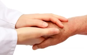 רופא מחזיק ידיים למטופל בגיל הזהב